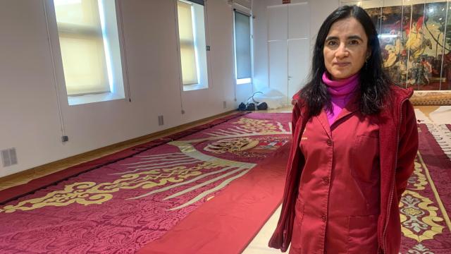 Verónica García Blanco, la Directora de Restauración de la Real Fábrica de Tapices, junto al telón telón de boca del Teatro Español.