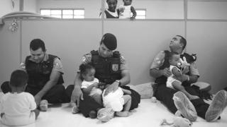 Una de las imágenes que se incluyen en el libro de Sarah Hrdy donde se ve a unos policías jugando y cuidando de bebés en un orfanato.