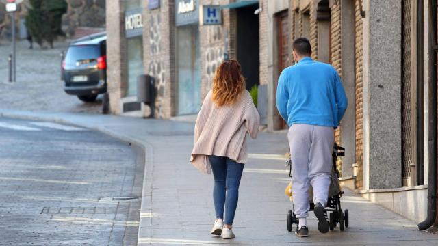Una pareja pasea a un bebé.