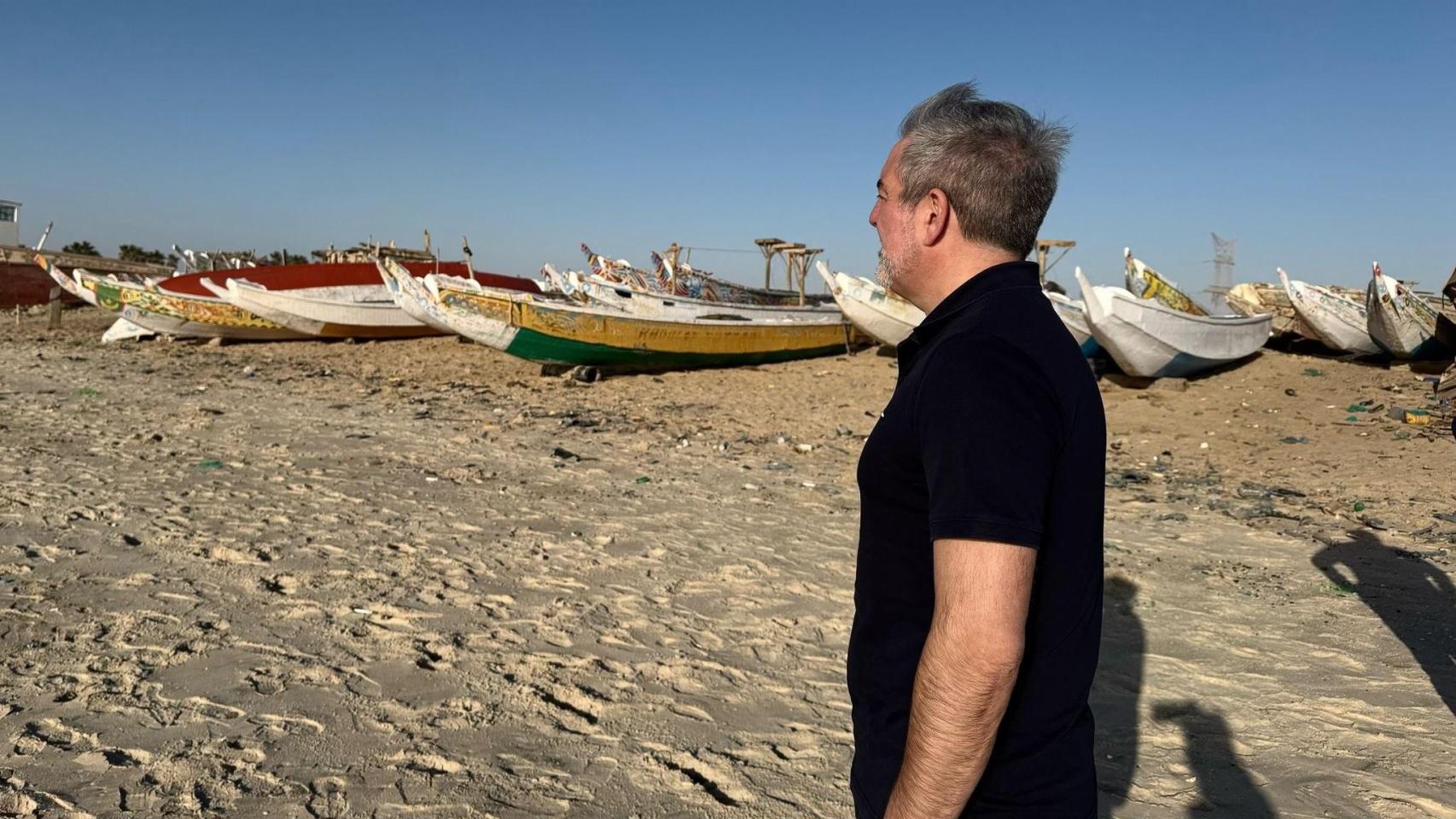Fernando Clavijo, presidente de Canarias, en una playa de Mauritania repleta de cayucos, listos para zarpar hacia las islas.