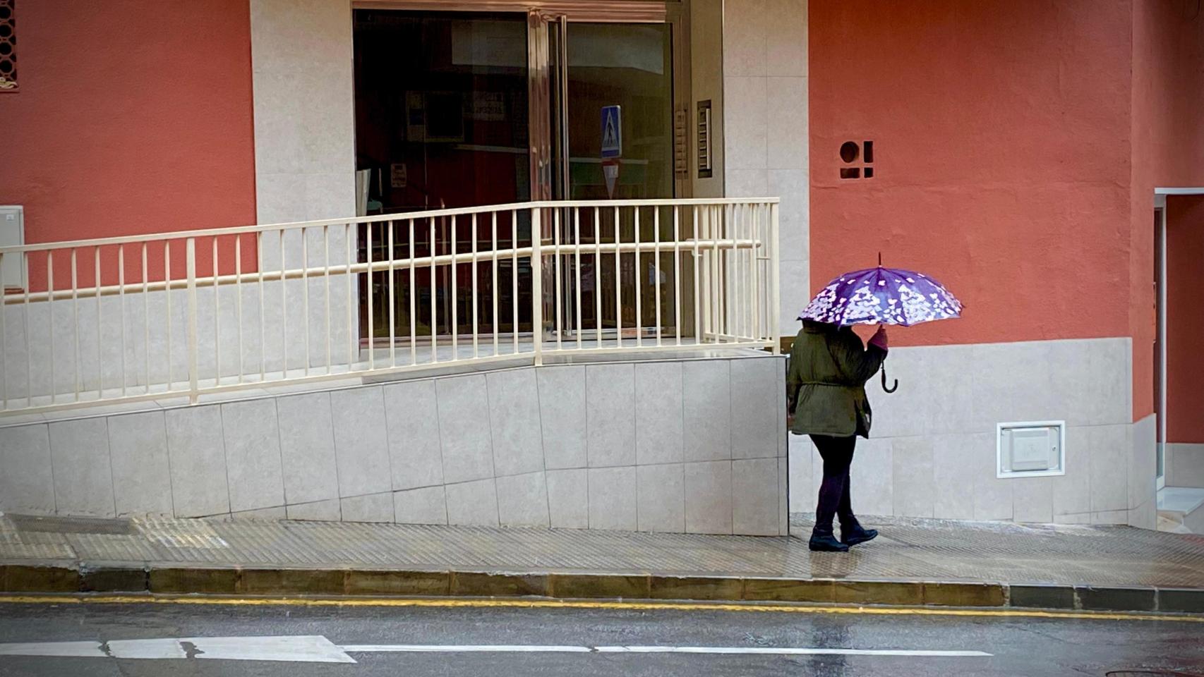 Una mujer protegiéndose de la lluvia en Málaga en una imagen de archivo.