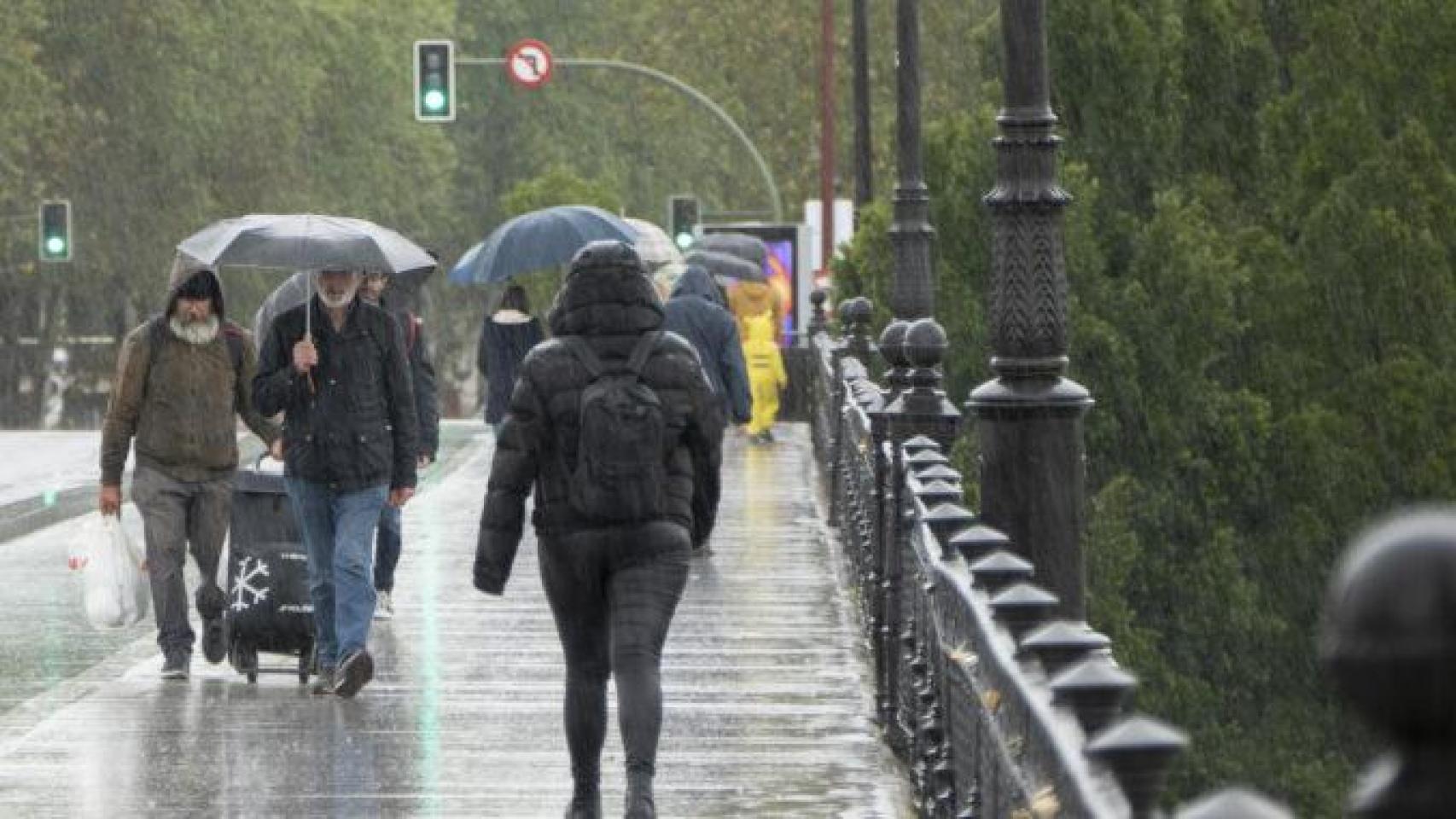 Varias personas se protegen de la lluvia intensa.