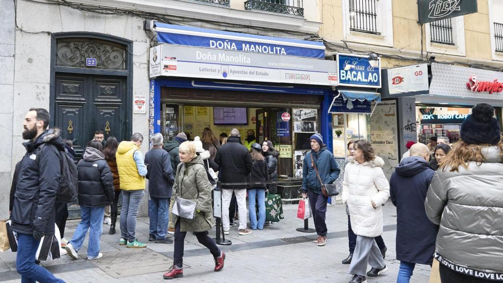 Varias personas hacen cola para comprar lotería.