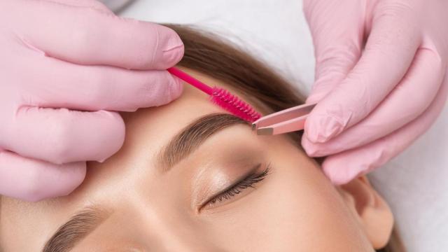 Imagen de archivo de una mujer haciéndose las cejas.