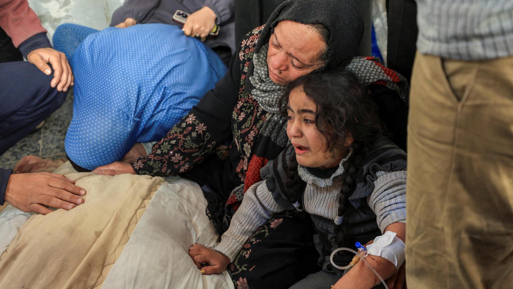 Una madre y su hija lloran la muerte de un familiar por un bombardeo israelí ayer en Gaza.