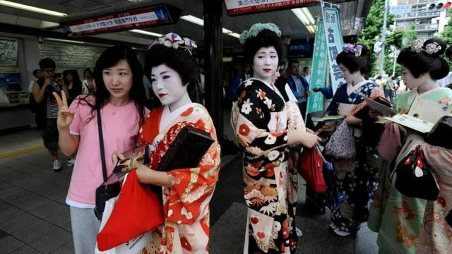 Una turista con un grupo de geishas en Kioto, Japón.
