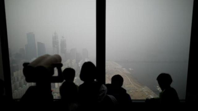 Unos niños observan la vista de Seúl cubierta por una densa niebla contaminante, en Seúl, Corea del Sur, el 15 de enero de 2019.