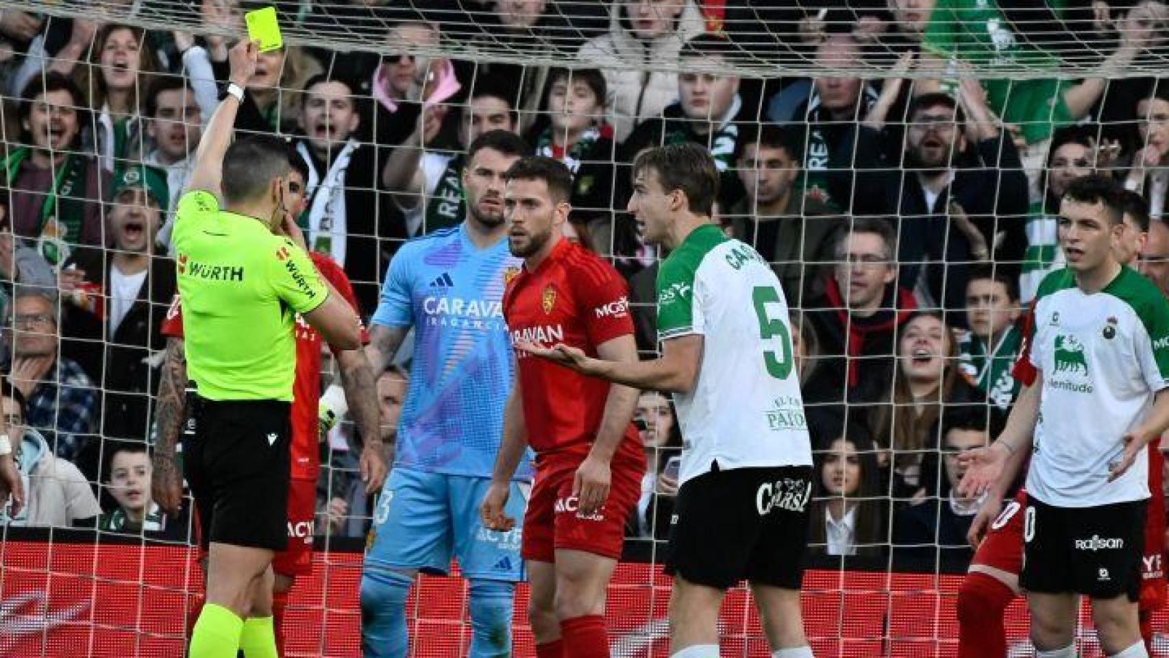 El colegiado enseña la amarilla a Iván Calero.