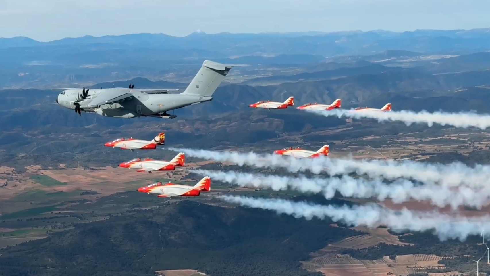 Patrulla Águila volando junto al A400M con la compuerta abierta