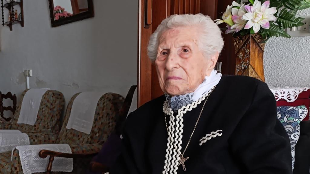 Concha Lax sostiene los globos de la celebración de su 110 cumpleaños; y a la izquierda, una foto de cuando hizo la comunión en 1924.