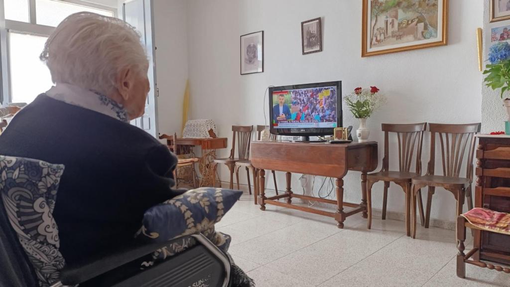 Concha Lax ve la televisión en la sala de estar de su casa, en Espinardo (Murcia).