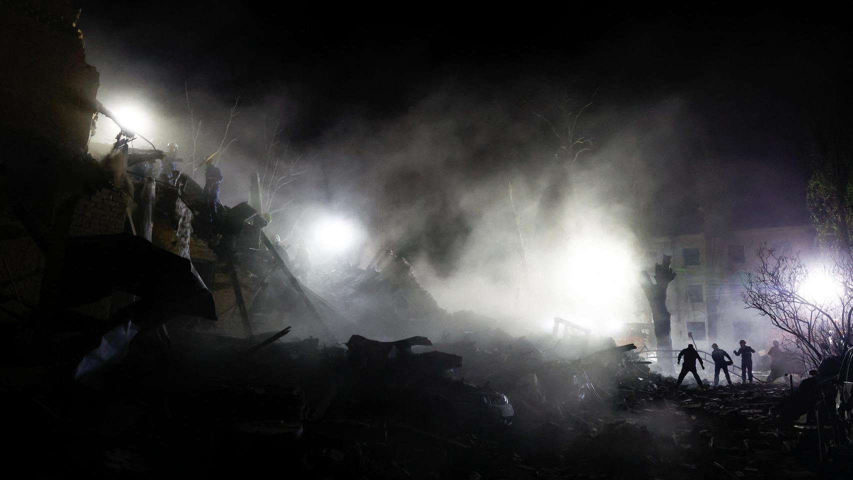 Rescatistas trabajan en el lugar de un edificio de apartamentos alcanzado por un ataque con misiles balísticos rusos en Kiev.