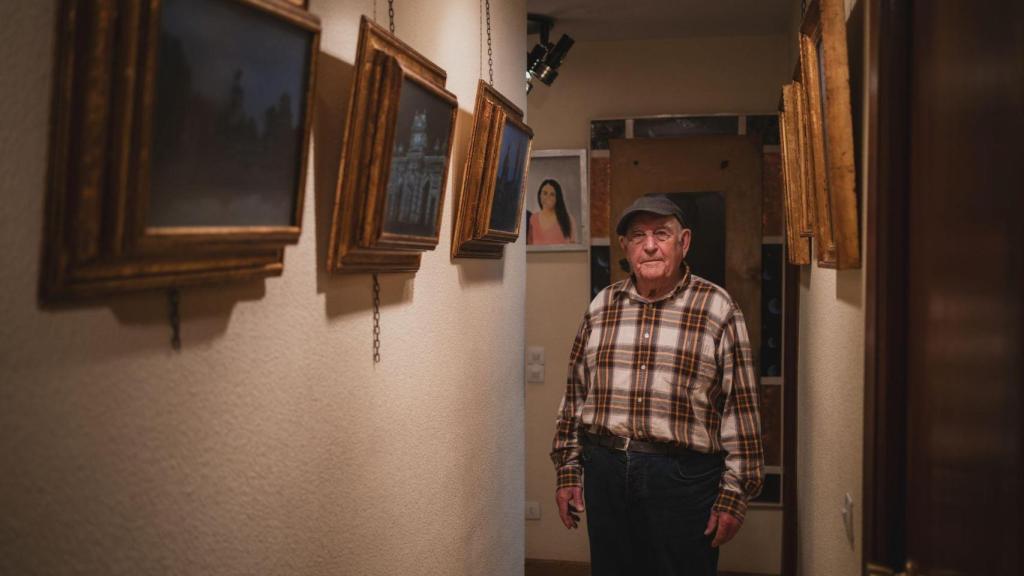 Mateo junto a los cuadros que expone en su casa.