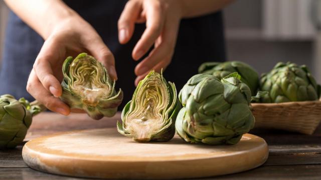 Una alcachofa sobre una tabla de madera.