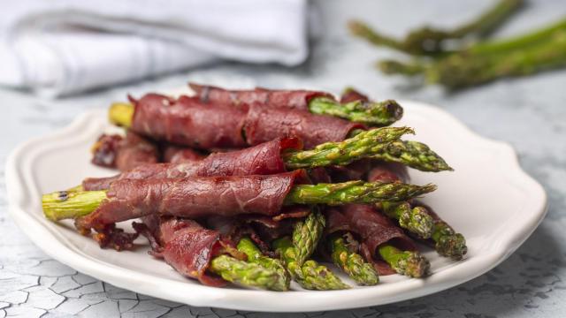 Un plato de espárragos con jamón