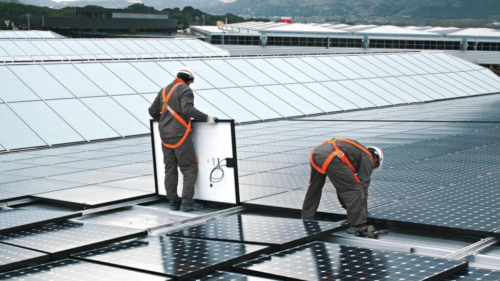 Los técnicos instalan las placas solares en la superficie del parque de Actiu en Castalla, Alicante.