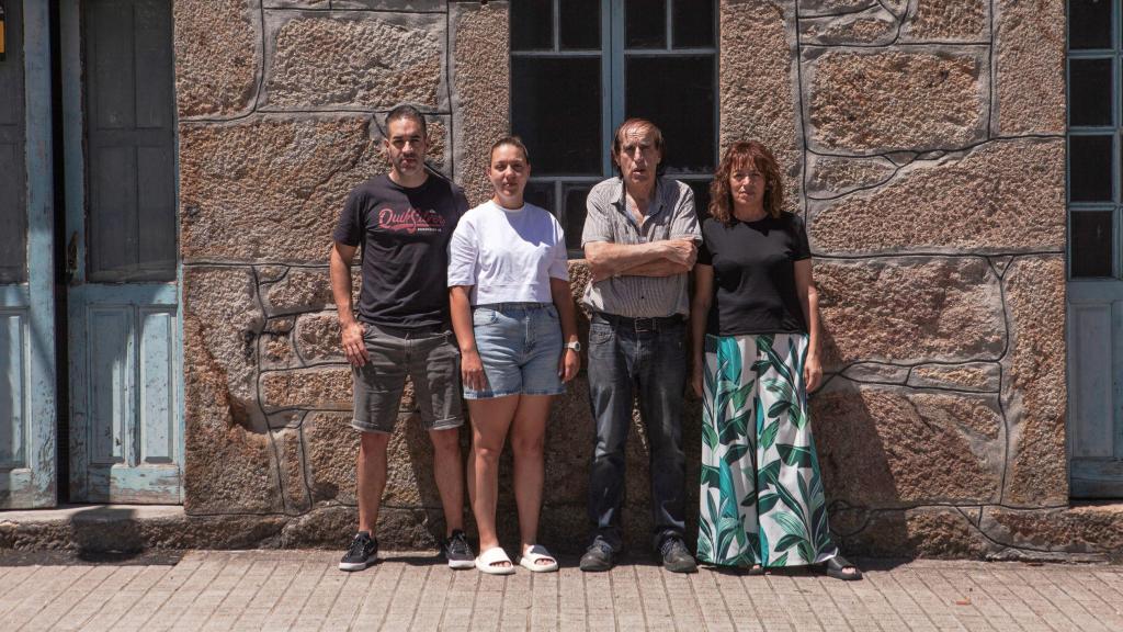 Vecinos de As Conchas, junto a la carretera que les separa del agua.