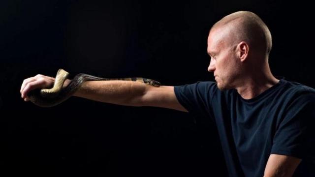 Tim Friede con una cobra de agua en el brazo.
