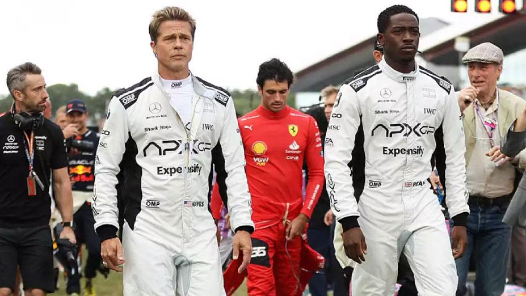 Carlos Sainz camina tras Brad Pitt y Damson Idris en el paddock de la F1