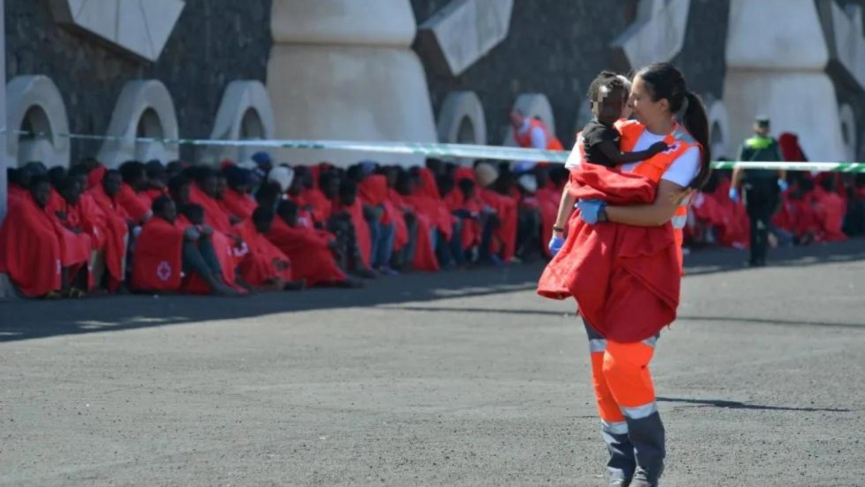 Una voluntaria de Cruz Roja atiende a una niña llegada a La Restinga, en El Hierro, el 21 de octubre.