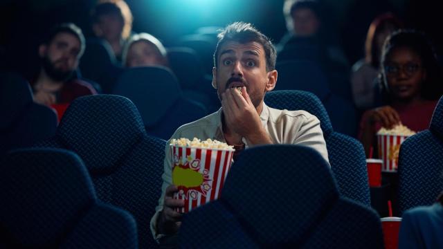 Imagen de archivo de un hombre comiendo palomitas en el cine
