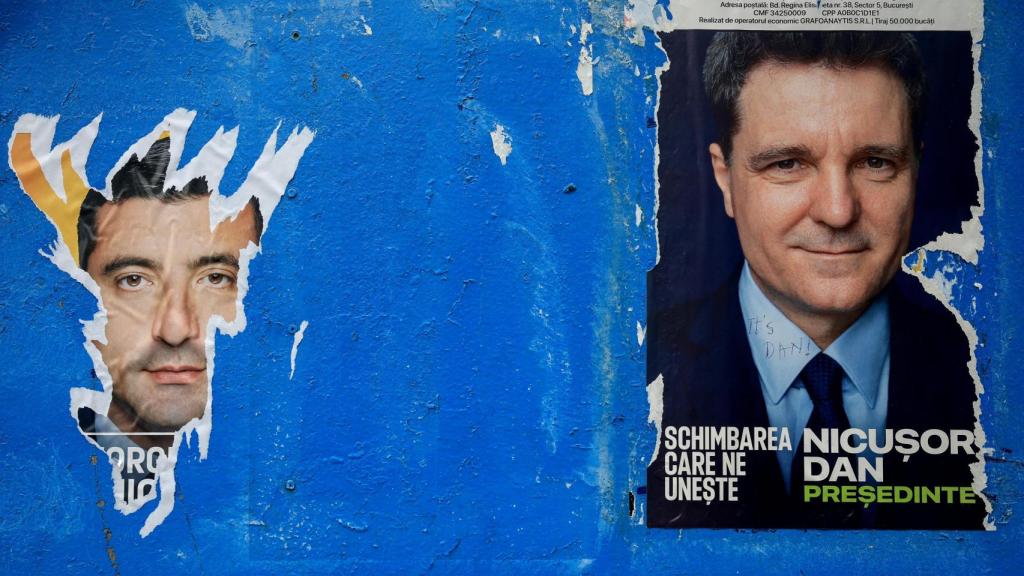 Un cartel arrancado del candidato presidencial George Simion se ve junto a uno de Nicușor Dan, antes de la segunda vuelta, en Bucarest.