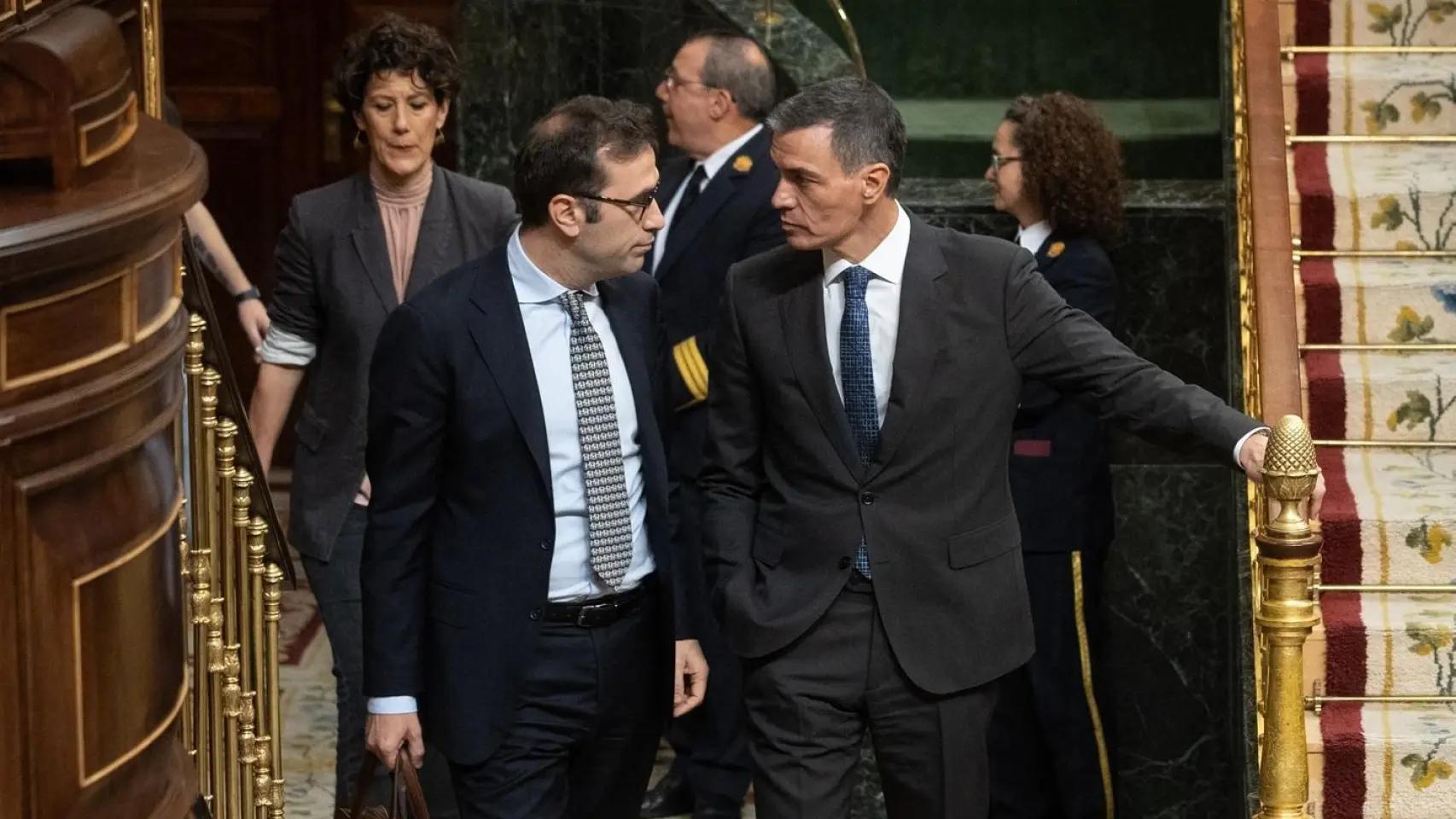 El ministro de Economía, Carlos Cuerpo (izq.), conversa con el presidente del Gobierno, Pedro Sánchez