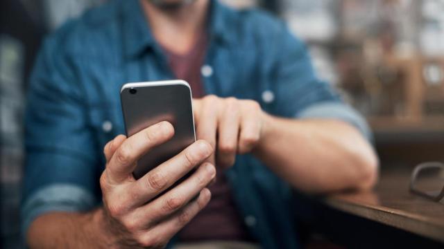 Imagen de archivo de un hombre utilizando su teléfono móvil