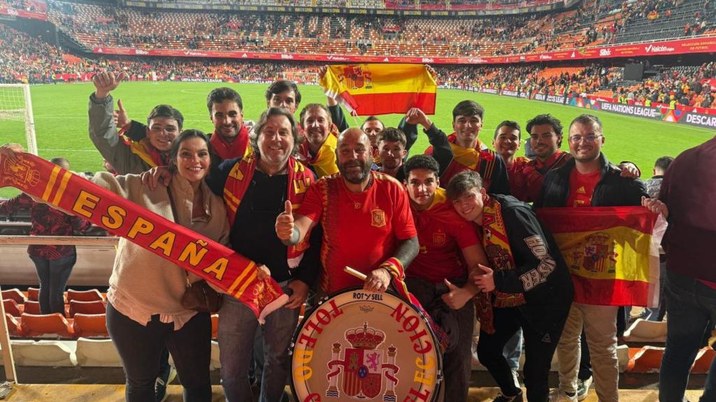 Curro, con su bombo, posando con decenas de aficionados españoles.