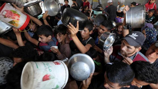 Palestinos esperan recibir comida preparada por una cocina benéfica en la ciudad de Gaza , el 21 de mayo de 2025.