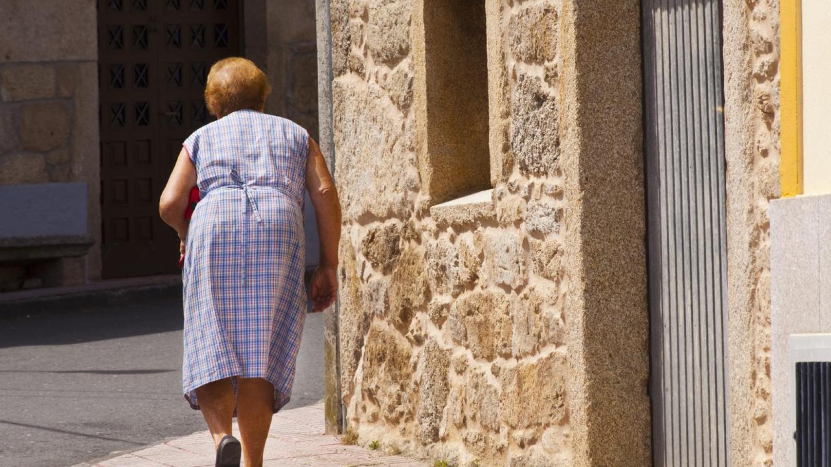 Una mujer caminando por un pueblo.