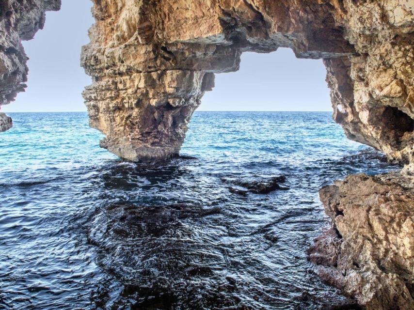 Las rocas forman estos arcos en la cala de Moraig.