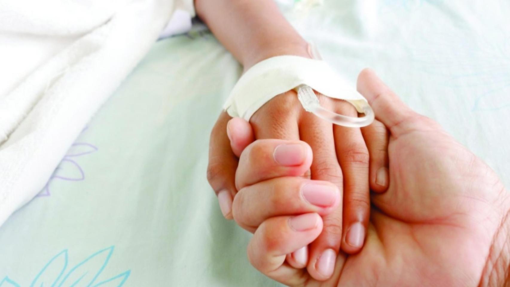 Médico sosteniendo la mano de un menor.