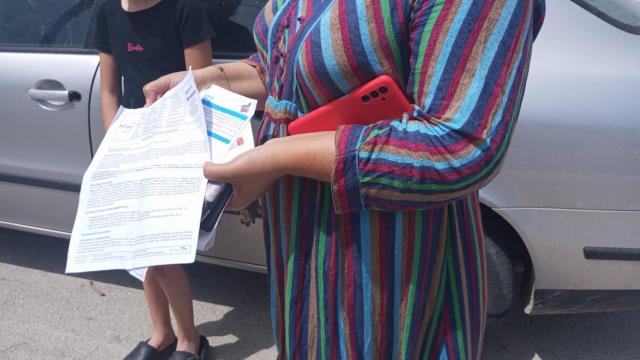Fátima, junto a su hija, de 8 años, mostrando el parte médico de La Arrixaca donde ingresó tras sufrir una descarga eléctrica en las Camas Locas de Alquerías.