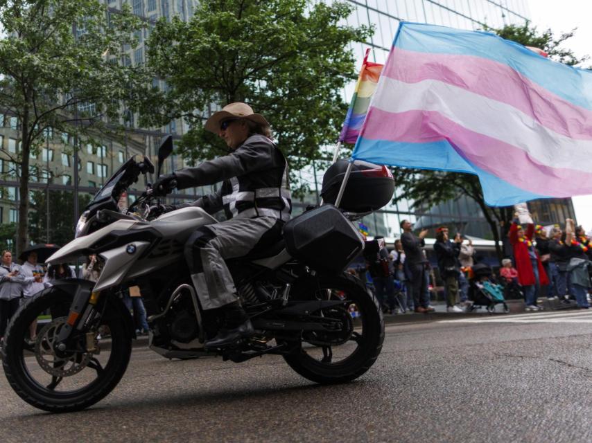 Un participante ondea la bandera trans y la bandera tradicional del orgullo gay desde una motocicleta durante el desfile Boston Pride for the People, en Boston, Massachusetts (EEUU), el 14 de junio de 2025.