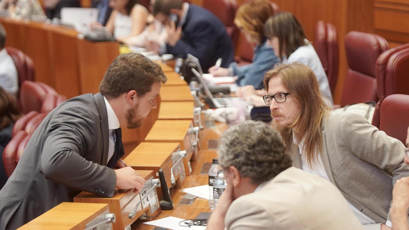 El procurador de Vox Miguel Suárez habla con el procurador de Unidas Podemos, Pablo Fernández, durante el pleno de las Cortes de Castilla y León donde se aprobó esta ley