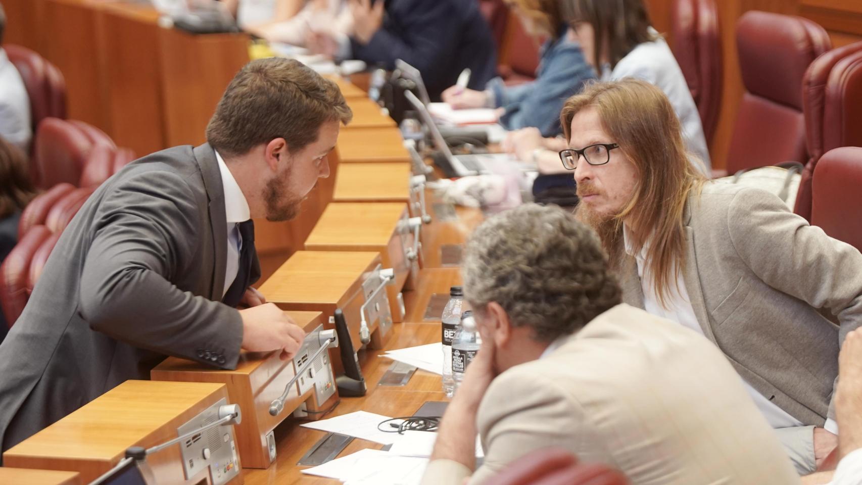 El procurador de Vox Miguel Suárez habla con el de Unidas Podemos, Pablo Fernández, durante el pleno de las Cortes en el que se aprobó la Ley de Publicidad Institucional, el pasado mes de junio
