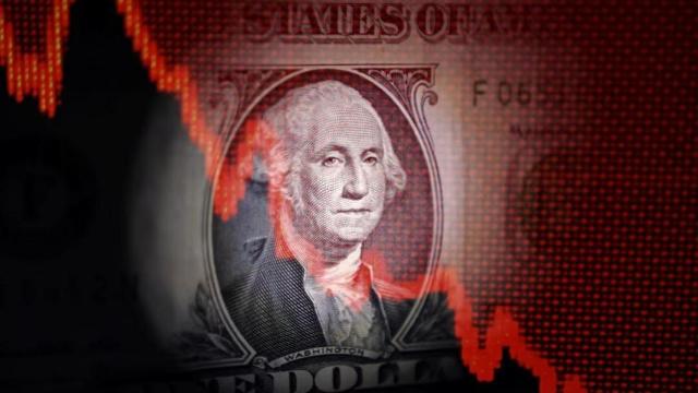 Un gráfico con tendencia bajista sobre un billete de dólar.