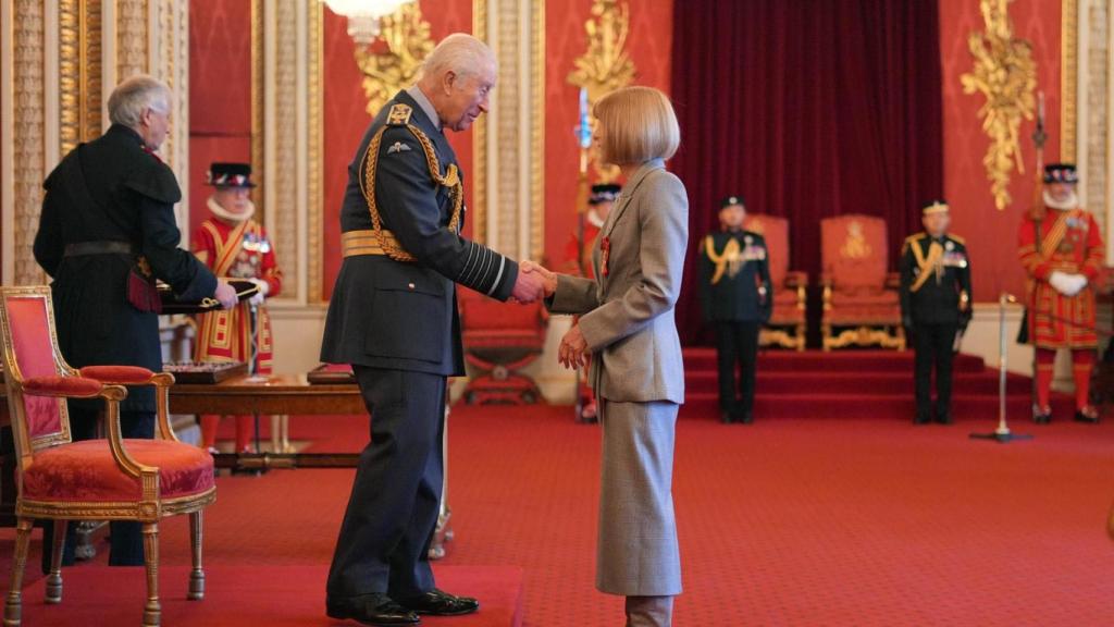 Anna Wintour recibiendo una condecoración de Carlos III.