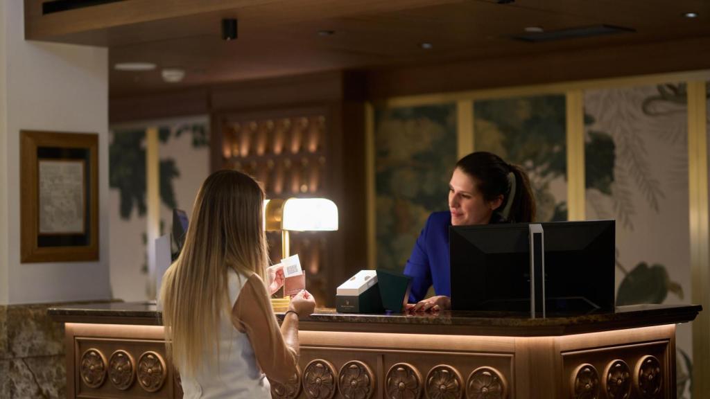 Una 'concierge' del Hotel Palace atendiendo a una huésped.