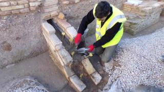 Un investigador toma muestras de las canalizaciones del yacimiento de San Esteban (Murcia) para enviarlas a analizar en laboratorio.