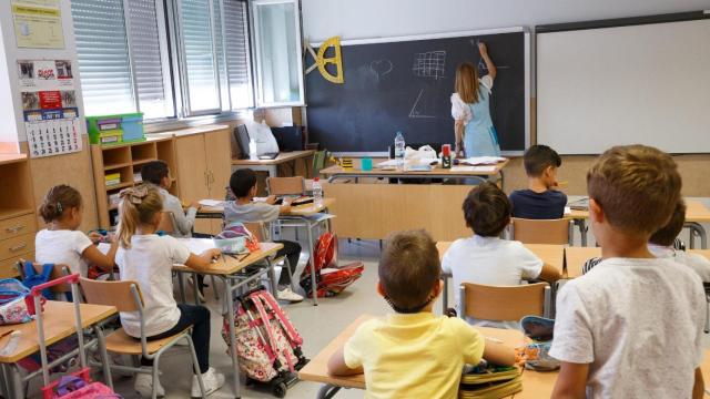 Una profesora dando clase a unos alumnos de primaria.