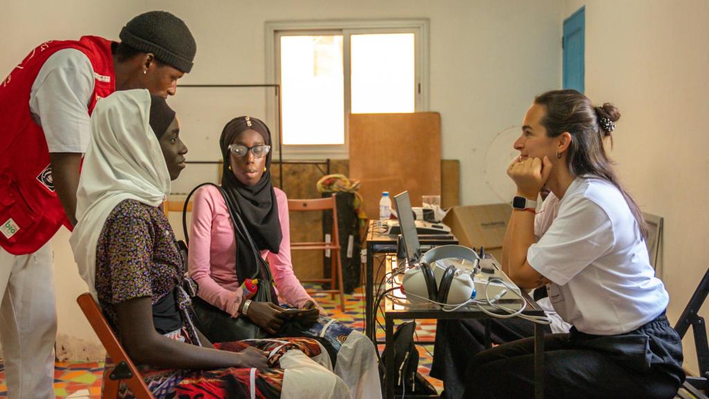 La audioprotesista de Fundación Multiópticas Judith Mendonza atiende a dos mujeres senegalesas con la ayuda de un traductor de Escuela Coruña.