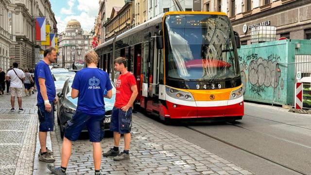 Varios hombres conversan junto a un tranvía detenido durante el apagón que afectó este viernes a Praga y otras partes de República Checa.