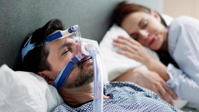 Hombre con CPAP, un tratamiento médico para la apnea del sueño y otros trastornos respiratorios