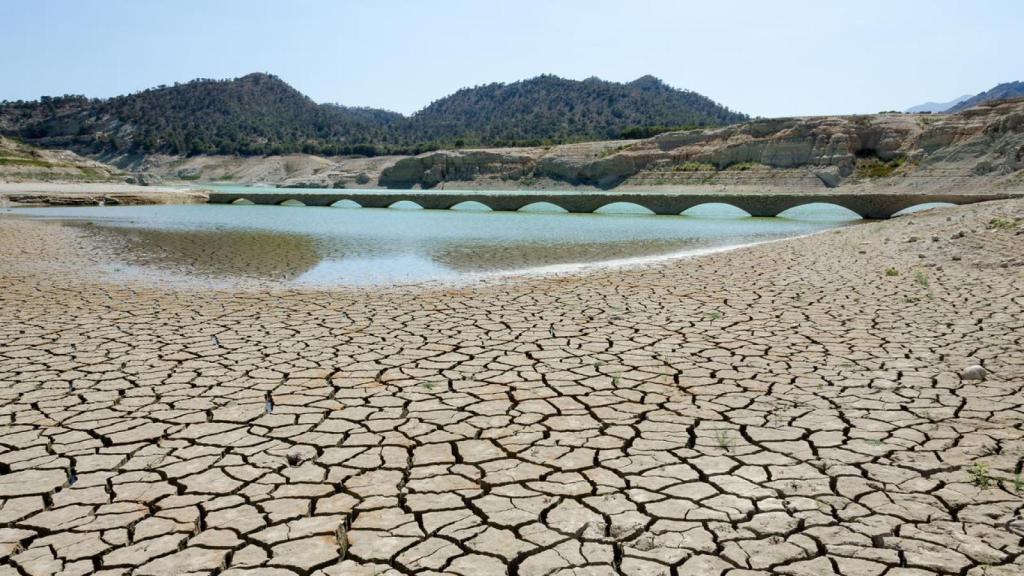 Un río seco con grietas hacia la cuenca del agua.