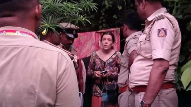 Nina Kutina rodeada de agentes de policía, en la entrada de su cueva.