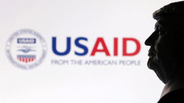 Una impresión 3D del presidente Donald Trump fotografiada junto al logo de USAID.