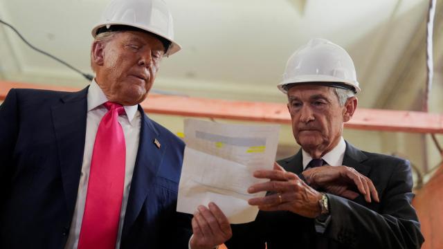 Donald Trump, presidente de Estados Unidos, pasa un documento al Jerome Powell, presidente de la Reserva Federal, durante una visita a un edificio del banco central que se está reformando.