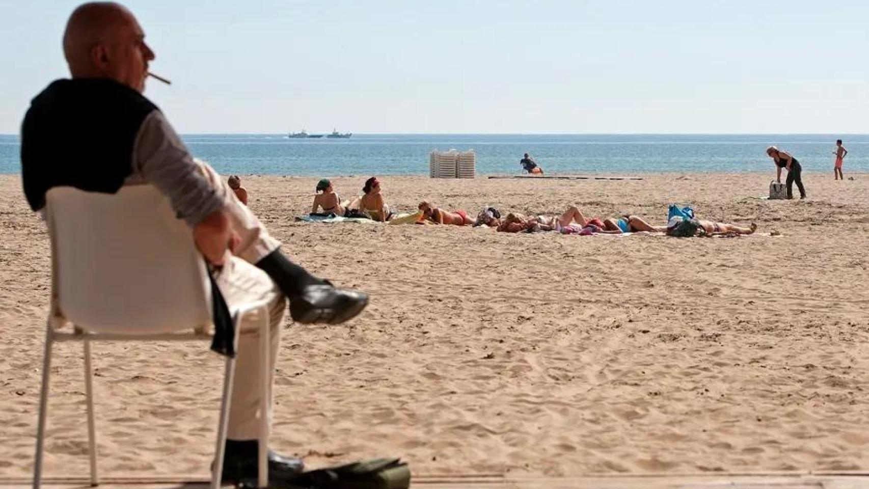 Un hombre fuma un cigarrillo en la playa de Las Arenas, en Valencia, en una imagen de archivo.